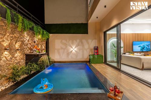 una piscina en medio de una sala de estar en StayVista at Stay-ish Villa with Pool, Wi-Fi, BBQ, en Amritsar