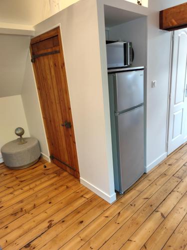 une chambre vide avec un réfrigérateur et une porte dans l'établissement Le Saut Mur, à Saumur