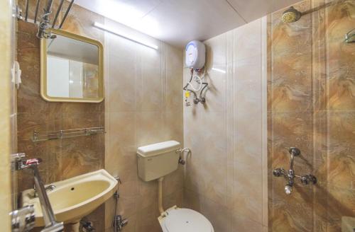 een badkamer met een toilet, een wastafel en een spiegel bij Vnest Dormitory in Mumbai