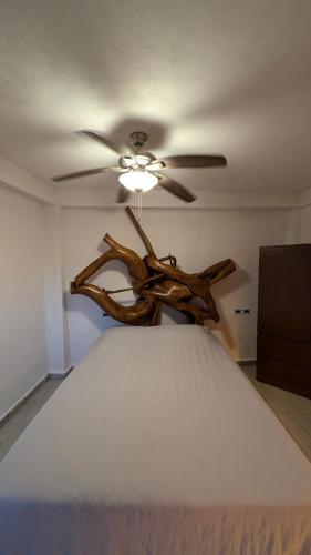 a ceiling fan in a room with a bed at Kajal Kiin in El Cuyo