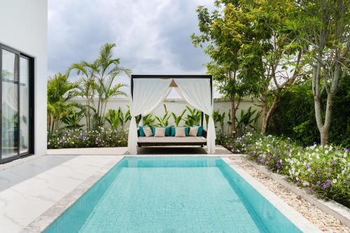 a villa with a swimming pool and a bed at Argo Pattaya Resort and Villas in Ban Huai Yai