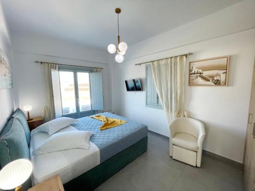 a bedroom with a bed and a chair at SAND villa in Monolithos