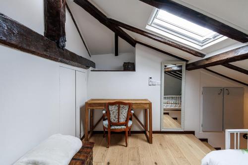 Cette chambre mansardée comprend un bureau et une chaise. dans l'établissement SICARDI - Elegant apartment in old town, à Menton