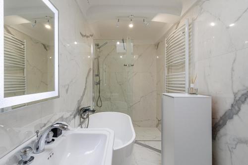 une salle de bain blanche avec un lavabo et une douche dans l'établissement SICARDI - Elegant apartment in old town, à Menton