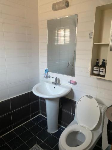 a bathroom with a white sink and a toilet at American House in Namhae