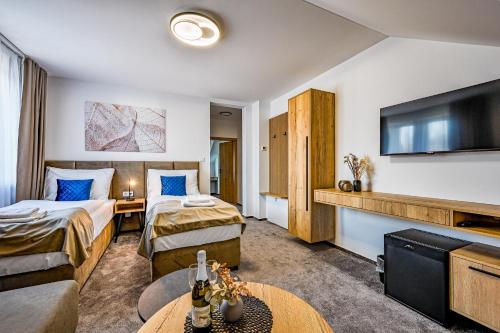 a hotel room with two beds and a flat screen tv at PENZIÓN u JAKUBA & REŠTAURÁCIA Bezplatné Parkovanie in Martin