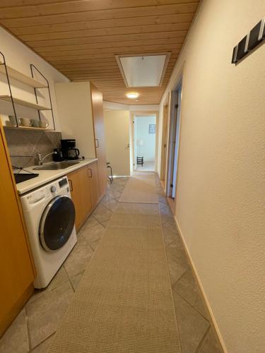 a hallway of a kitchen with a washer and dryer at Garden Rooms Billund in Billund