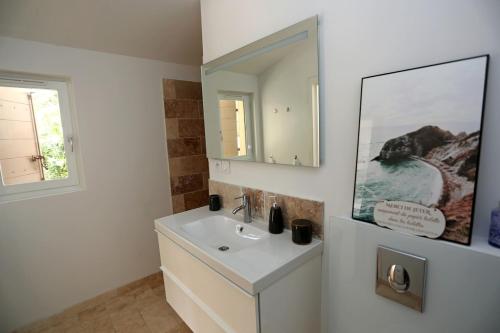 une salle de bain blanche avec un lavabo et un miroir dans l'établissement Villa Mas Mavie avec Piscine Les Baux-de-Provence, aux Baux-de-Provence