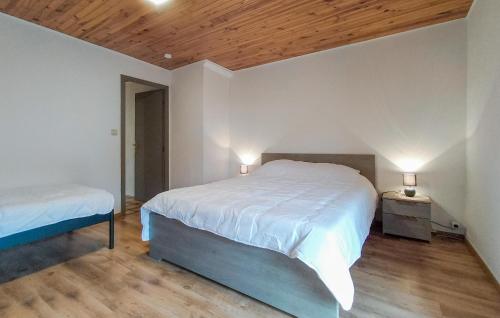 a bedroom with two beds and a wooden ceiling at 2 Bedroom Pet Friendly Home In Treignes in Treignes