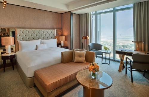 a hotel room with a bed and a couch and a desk at Waldorf Astoria Dubai International Financial Centre in Dubai