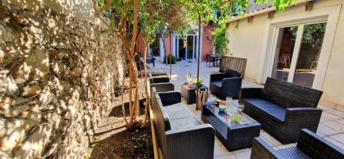 un groupe de chaises et une table à côté d'un mur dans l'établissement ESPRIT LOFT, Appartement d'Exception, 3 chambres, Jardin au Centre Ville, Climatisation, à Sète