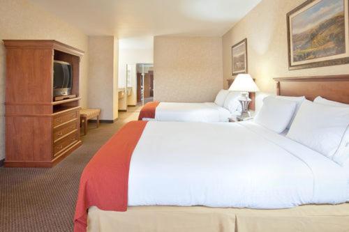 a hotel room with two beds and a television at Holiday Inn Express Hotel & Suites Barstow by IHG in Barstow