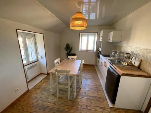 une cuisine avec une table et une salle à manger dans l'établissement La Ferme de Gabriela, logement haut de gamme dans le Jura, à Châtillon