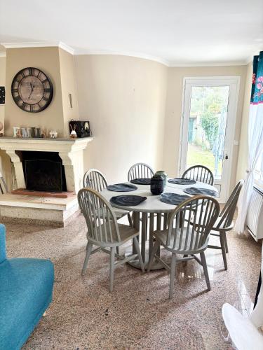 une salle à manger avec une table et des chaises et une cheminée dans l'établissement La maison des Epinouses, 4 chambres à 450M de la plage de Chaucre, à Saint-Georges-dʼOléron