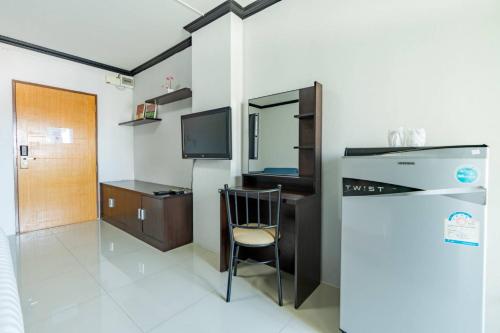 a room with a chair and a desk and a television at One Residence Navanakorn in Pathum Thani