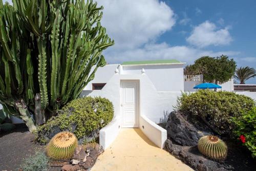 a white house with a white door and some plants at Apartment Luna FKK Nudist Place in Charco del Palo