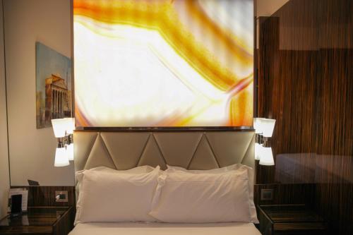 a bed in a hotel room with a large painting above it at Le Boutique Hotel in Rome