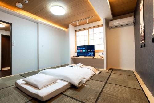 a large bed in a room with a television at ohayo両国 in Tokyo
