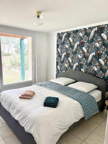 - une chambre avec un grand lit et un mur avec des poissons dans l'établissement La maison des Epinouses, 4 chambres à 450M de la plage de Chaucre, à Saint-Georges-dʼOléron