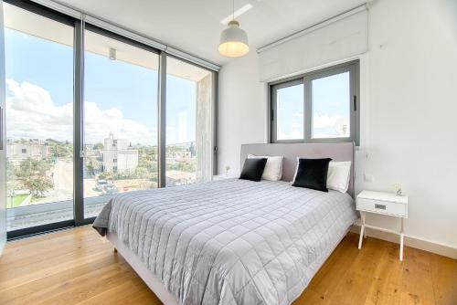 a bedroom with a large bed and large windows at Avenue 201 2 BED in Paphos