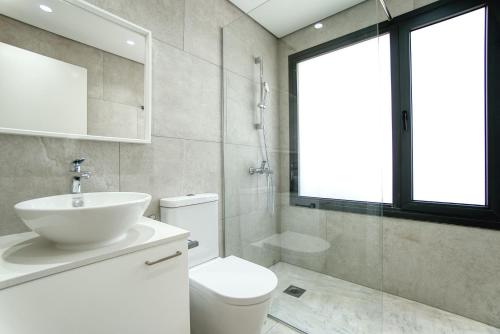 a white bathroom with a sink and a toilet at Avenue 201 2 BED in Paphos