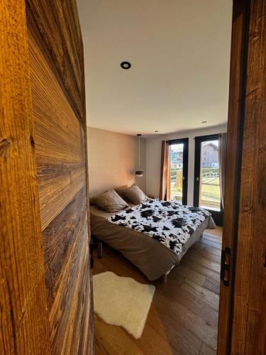 - une chambre avec un lit et une grande porte en bois dans l'établissement Chalet Sassy Evasion Cocooning Jardin et BOX, à Megève