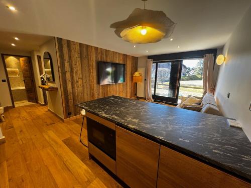 une cuisine avec un comptoir noir dans une pièce dans l'établissement Chalet Sassy Evasion Cocooning Jardin et BOX, à Megève