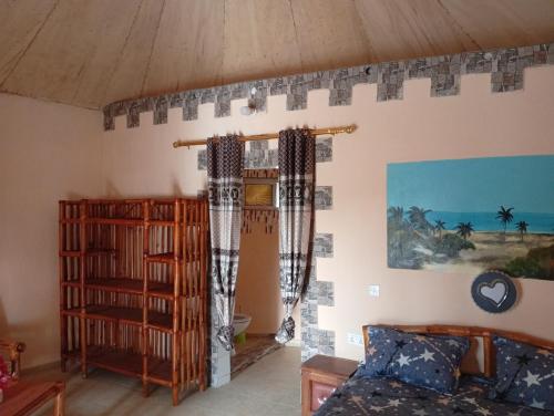 a living room with a couch and a book shelf at Nyantanto Eco Lodge in Gunjur