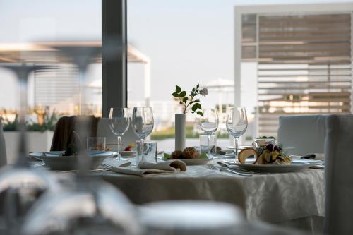 a table with glasses and plates of food on it at Hotel Le Soleil in Lido di Jesolo