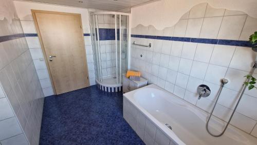 a bathroom with a bath tub and a shower at Ferienwohnung Wiesental II, Wiesentalstrasse 1, 89331 Burgau in Burgau