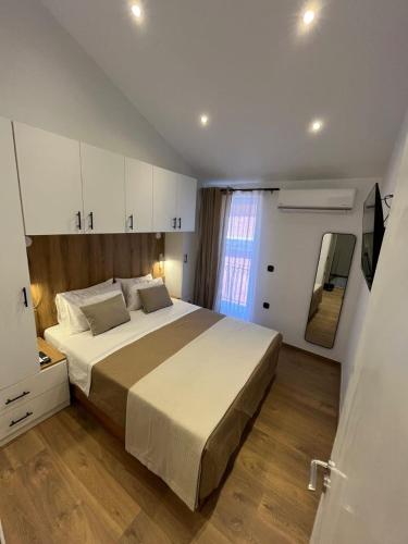 a bedroom with a large bed and a television at Petite Maisonnette at Garitsa! in Corfu International Airport I Kapodistrias