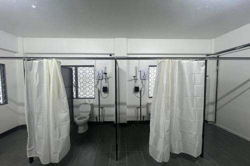 a bathroom with two showers and a toilet at Makotel Hostel Ipoh in Ipoh