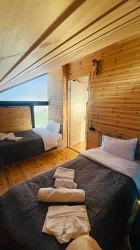 a bedroom with two beds in a wooden room at Akhalsheni House in Batumi