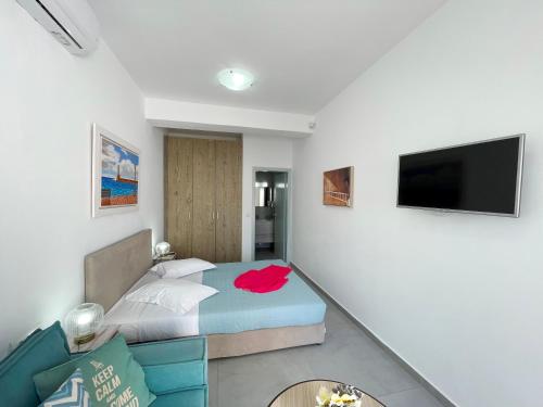 a bedroom with a bed and a flat screen tv at SEA and SAND villa in Monolithos