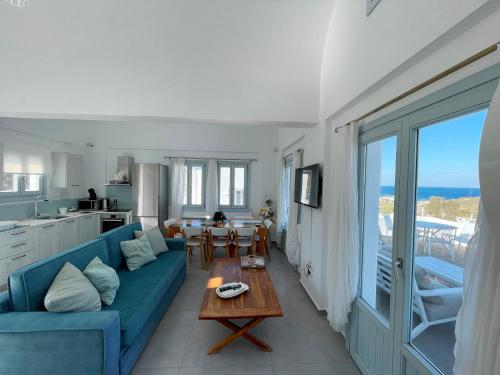 a living room with a blue couch and a table at SEA and SAND villa in Monolithos