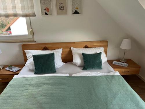 a bedroom with a bed with green and white pillows at Ferienwohnung Lee in Bad Neuenahr-Ahrweiler