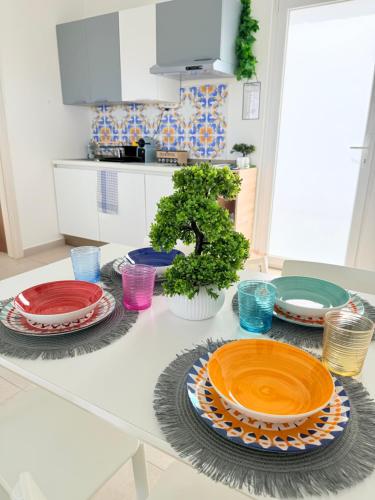 a table with plates and bowls on it in a kitchen at Vistamare Oltremare in San Cataldo