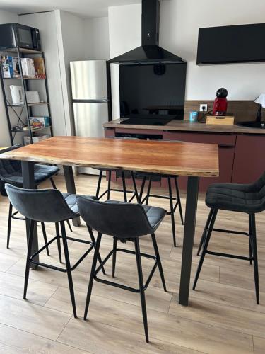 - une table et des chaises en bois dans la cuisine dans l'établissement Les vosgiens, à Gérardmer