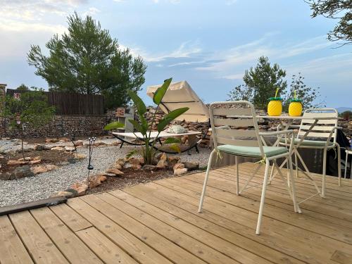two chairs and a table on a wooden deck at Suite Caravan by Noches de Calig in San Jorge