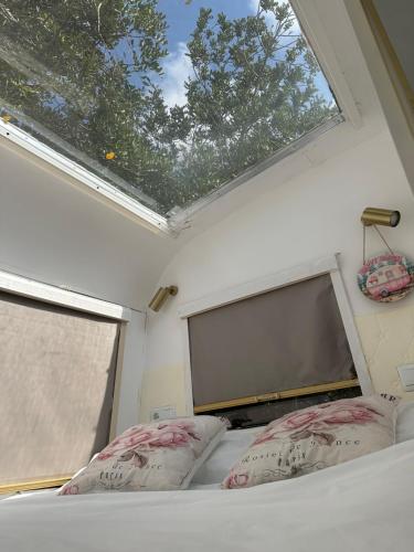 a bedroom with a bed with two pillows and a window at Suite Caravan by Noches de Calig in San Jorge