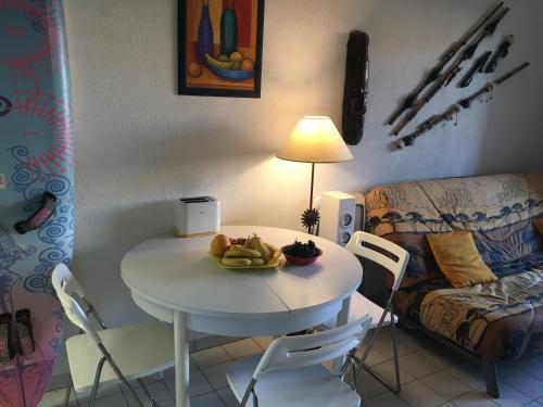 - une table blanche avec un bol de fruits dans le salon dans l'établissement Grauplage, au Grau-dʼAgde