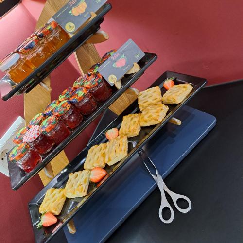 two trays of food on a table with scissors at Allgäuhotel Memmingen Nord in Memmingen