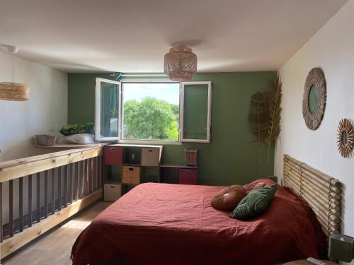 a bedroom with a bed with a red blanket and a window at Vien bat'karé - L'Étang Salé Les Bains in Étang-Salé les Bains