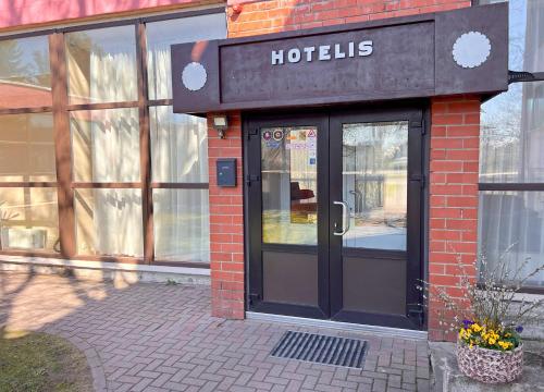 a hotel entrance with ajar doors on a brick building at Park Hotel Kekava in Ķekava