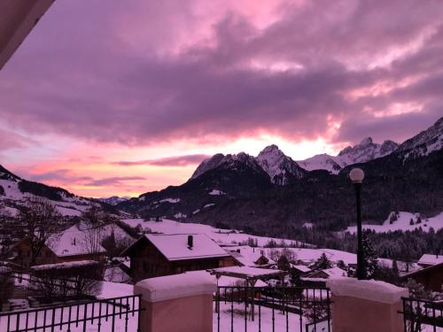 a winter sunset with snow covered mountains in the background at Rosat 2 in Chateau-d'Oex