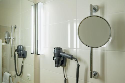 a shower with a mirror in a bathroom at Aspire Oldenburg, Trademark Collection by Wyndham in Oldenburg