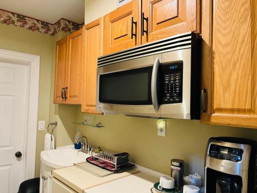 a kitchen with a microwave above a sink at Barker House 3# Suite-heart of oldtown in Niagara on the Lake