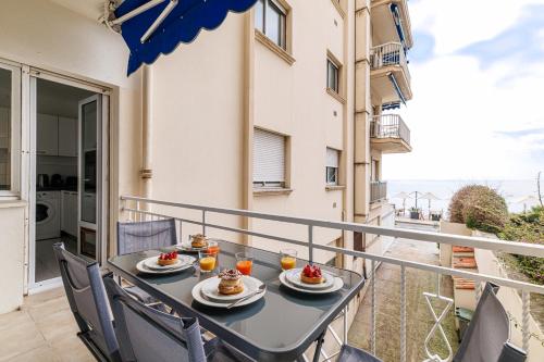 une table avec deux assiettes de nourriture sur un balcon dans l'établissement MAR Y NAN - Spacieux appartement face à la mer, à Menton
