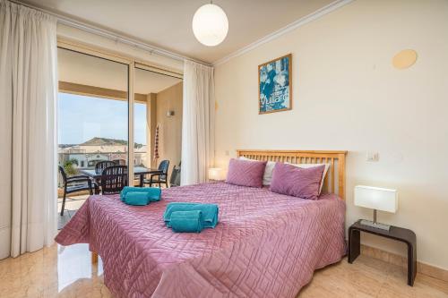 Un dormitorio con una cama grande con una manta morada. en Apt Brightness Comfort In Burgau, en Burgau
