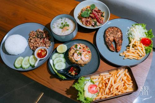 a wooden table with plates of food and rice at เลอค่าเชียงแสน Le Quar Cafe BistroBed & Breakfast in Golden Triangle
